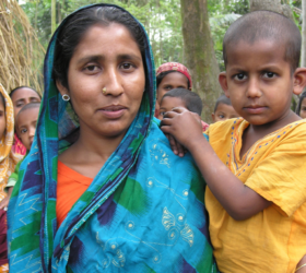 Photo showing a group of Bangladeshi women and their children in traditional clothing.