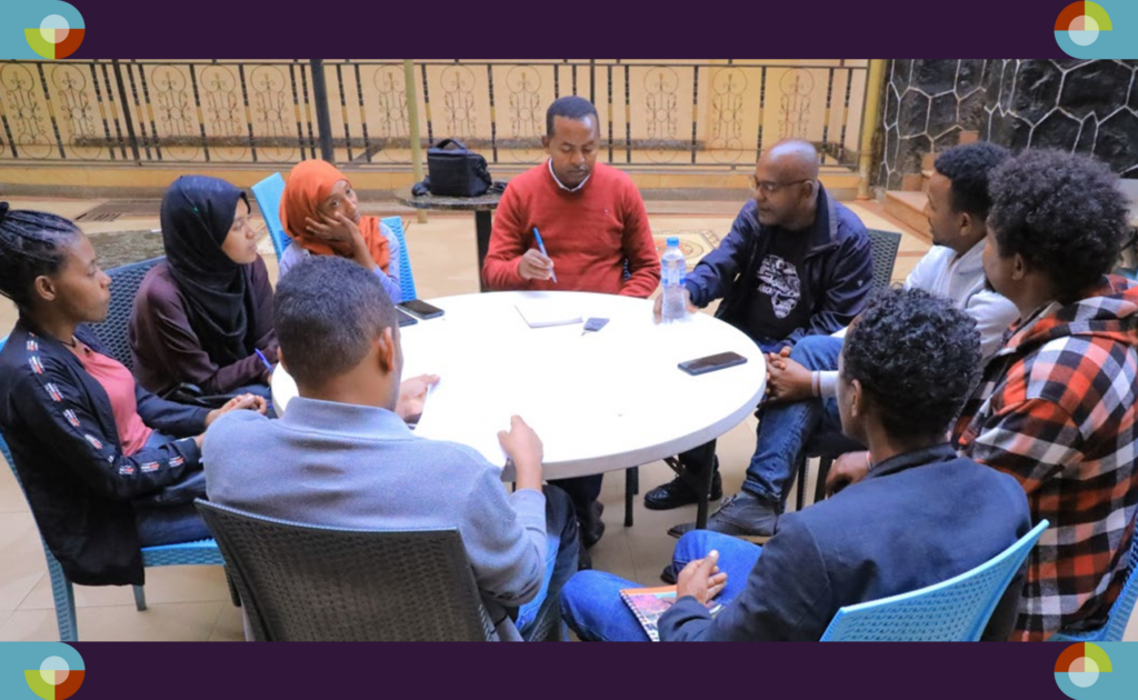 Photo showing a group of Ethiopian data collectors sitting around a table. 