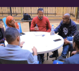 Photo showing a group of Ethiopian data collectors sitting around a table.