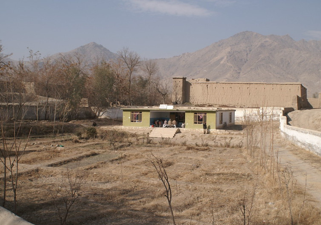 Photo showing a building with people inside it in the moutains of Afghanistan. 